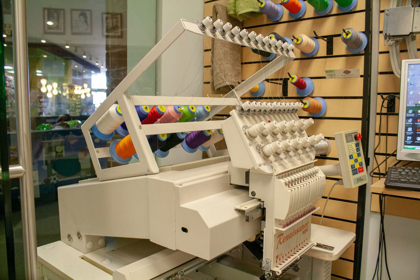 Macchina da ricamo professionale con rocchetti di filo colorato